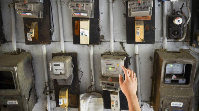 Warga memeriksa meteran listrik. Foto: ANTARA FOTO/Nova Wahyudi