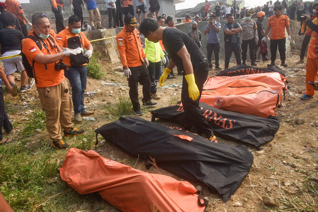 Petugas mengevakuasi tujuh jenazah laki laki yang ditemukan mengambang di Kali Bekasi, Pondok Gede Permai, Jatiasih, Kota Bekasi, Minggu (22/9/2024). Foto: Rezas Ale/ANTARA FOTO