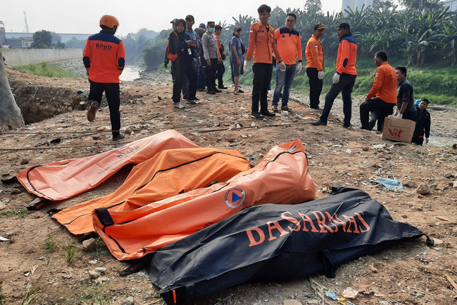 Petugas mengevakuasi tujuh jenazah laki laki yang ditemukan mengambang di Kali Bekasi, Pondok Gede Permai, Jatiasih, Kota Bekasi, Minggu (22/9/2024).  Foto: Rezas Ale/ANTARA FOTO