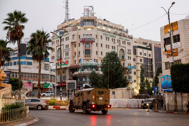 Kendaraan militer berpatroli di jalan di luar gedung tempat kantor Al Jazeera berada di Ramallah, Tepi Barat, Minggu (22/9/2024). Foto: Mohammed Torokman/REUTERS
