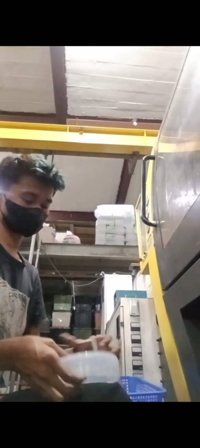 Gambar pekerja pabrik menggunakan masker yang sedang memegang tutup toples. Foto: Milik pribadi 