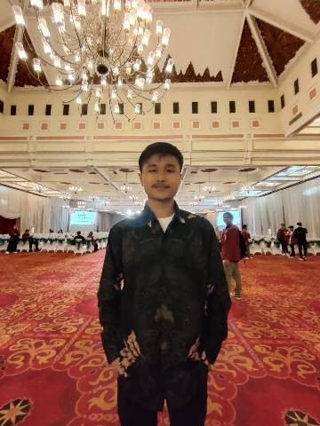 Gambar seseorang sedang berdiri di dalam ruangan dan mengenakan baju batik. Foto: Milik pribadi. 