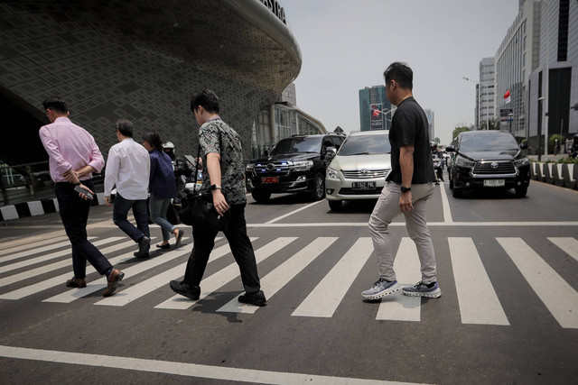 Sejumlah warga melintasi pelican crossing di kawasan Bundaran HI, Jakarta, Selasa (8/10/2024). Foto: Jamal Ramadhan/kumparan