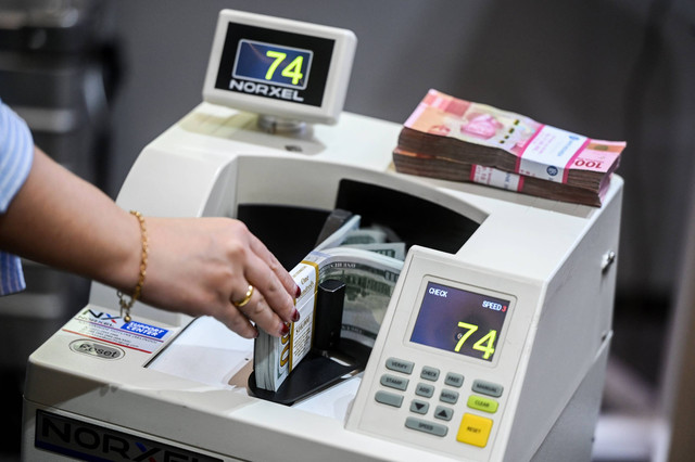 Petugas menghitung uang pecahan dolar AS di Bank Mandiri, Jakarta, Jumat (11/10/2024). Foto: ANTARA FOTO/Rivan Awal Lingga