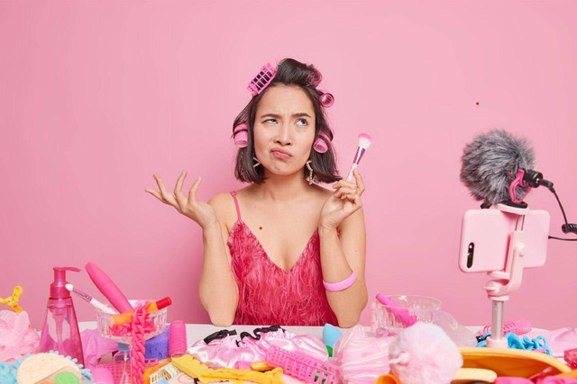 Beauty content creator yang tengah melakukan perekaman video di kamar dengan banyak produk (https://www.freepik.com)