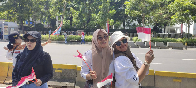 Warga asal Purwakarta dan Garut, Siti dan Endah, saat menanti kedatangan Prabowo-Gibran di Jalan Jenderal Sudirman, Minggu (20/10/2024). Foto: Rachmadi Rasyad/kumparan