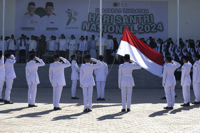 Santri pesantren Daarut Tahfizh Al-Ikhlas mengibarkan bendera Merah Putih pada peringatan hari santri nasional di Aceh Besar, Aceh, Selasa (22/10/2024). Foto: Irwansyah Putra/ANTARA FOTO