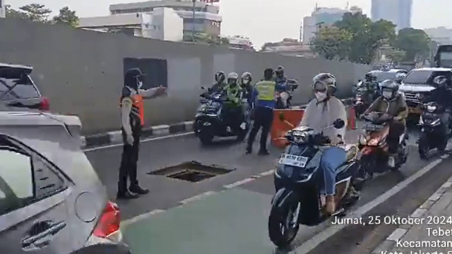 Sejumlah kendaraan melintas di dekat Gorong-Gorong yang terbuka akibat dicuri oleh orang di Jalan MT Haryono, Jakarta, Jumat (25/10/2024). Foto: X/ @TMCPoldaMetro