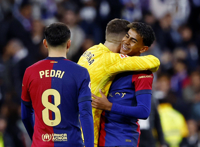 Inaki Pena dan Lamine Yamal dari FC Barcelona merayakan selebrasi setelah pertandingan La Liga antara Real Madrid melawan Barcelona di Santiago Bernabeu, Madrid, Spanyol, Minggu (27/10/2024) dini hari. Foto: Susana Vera/REUTERS 