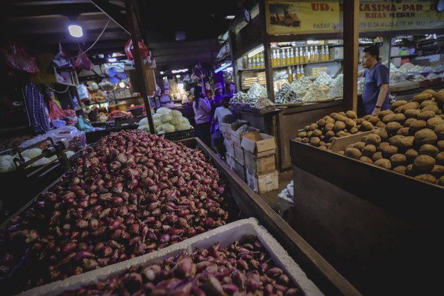 Calon pembeli melintas di dekat bawang merah yang dijual di Pasar Senen, Jakarta, Jumat (1/11/2024). Foto: Jamal Ramadhan/kumparan
