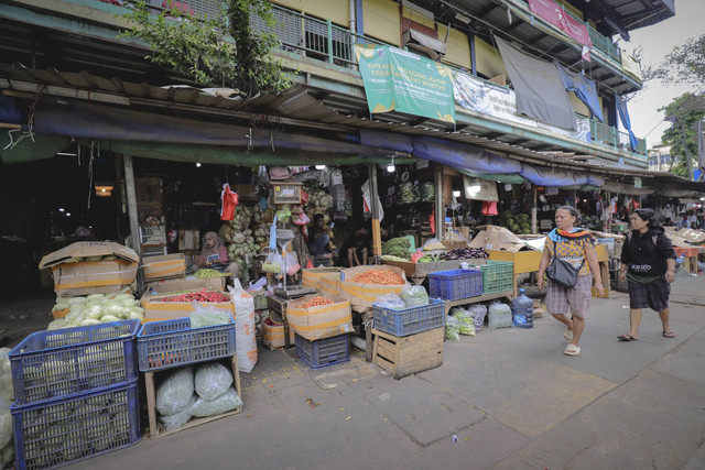 Calon pembeli melintas di dekat pangan yang dijual di Pasar Senen, Jakarta, Jumat (1/11/2024). Foto: Jamal Ramadhan/kumparan