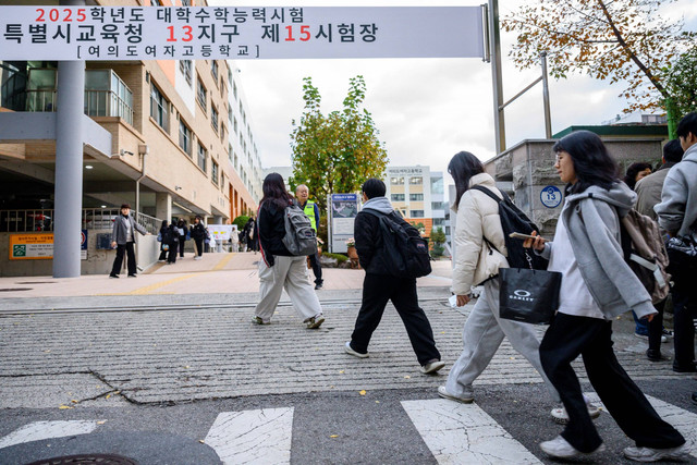 Sejumlah siswa tiba jelang mengikuti Ujian Kemampuan Skolastik Perguruan Tinggi tahunan yang dikenal secara lokal sebagai Suneung di Yeouido Girls High School, Seoul, Korea Selatan, Kamis (14/11/2024). Foto: ANTHONY WALLACE / AFP