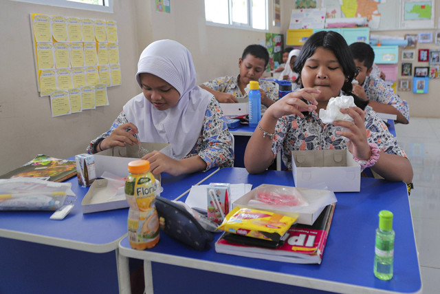Sejumlah siswa menyantap makanan saat simulasi program Makan Siang Bergizi Gratis di sekolah wilayah Lanud Halim Perdanakusuma di SDS Angkasa 5 Lanud Halim Perdanakusuma, Jakarta, Selasa (26/11/2024). Foto: Iqbal Firdaus/kumparan