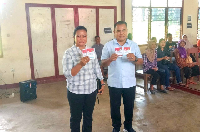 Bupati Sekadau Aron bersama istri menunjukkan surat suara di TPS 14 Desa Sungai Ringin. Foto: Dok. Istimewa