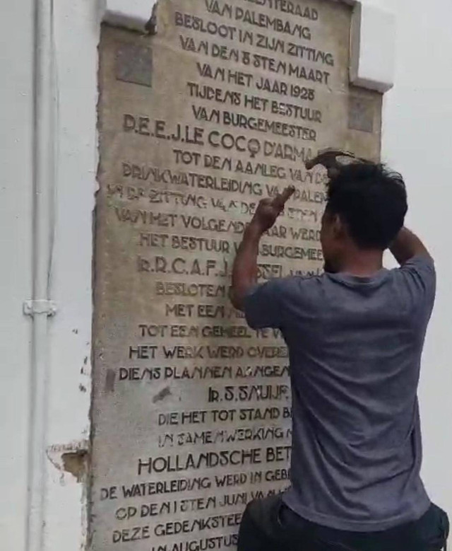 Tukang Bangunan saat membersihkan sisa semen di Prasasti peninggalan masa Kolonial Belanda di Kantor Wali Kota Palembang. Foto : Istimewa/Potongan Video