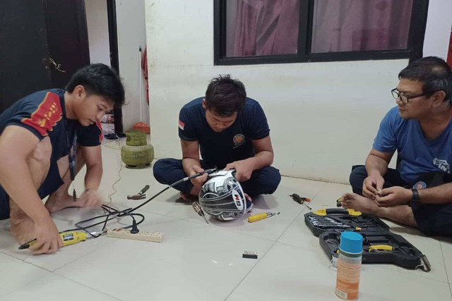 Petugas Damkar Depok bantu warga yang minta baut di helemnya dilepas. Foto: Damkar Depok