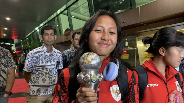 Viny Silfianus pamerkan trofi ASEAN Women's Cup saat Timnas Wanita Indonesia pulang dari Laos. Foto: Aji Nugrahanto/kumparan