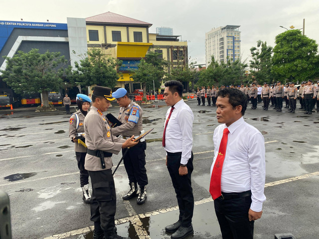 Kapolresta Bandar Lampung, Kombes Pol Abdul Waras saat memberikan penghargaan kepada Aipda Deni Oktarian dan Bripka Moris Mara Tanjung. | Foto: Sinta Yuliana/Lampung Geh