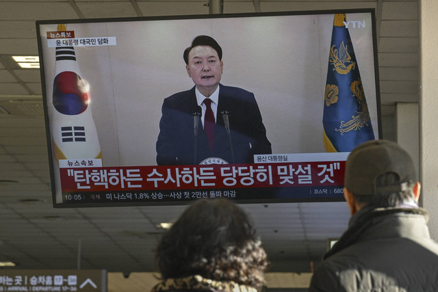 Sebuah layar menunjukkan Presiden Korea Selatan Yoon Suk Yeol berbicara dalam pidato yang disiarkan di televisi di terminal bus di Seoul pada 12 Desember 2024.  Foto: Anthony Wallace/AFP