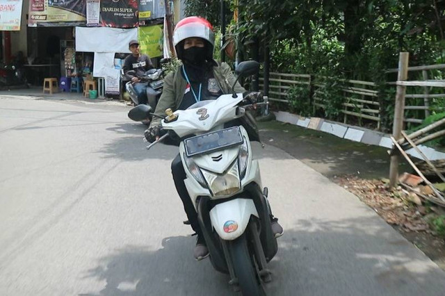 Pengemudi ojek online perempuan sedang mengantarkan pesanan makanan. (Foto: Syifa Khairunnisa Zahrah/Bandung)