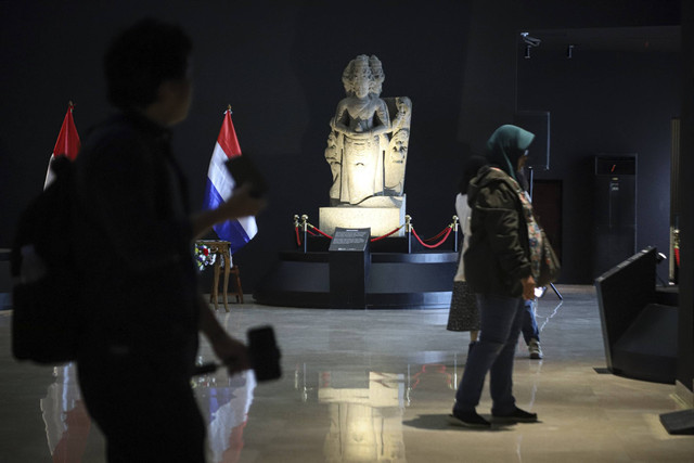 Pengunjung melintasi benda cagar budaya yang dipulangkan dari Belanda ke Indonesia di Museum Nasional, Jakarta, Senin (16/12/2024). Foto: Iqbal Firdaus/kumparan