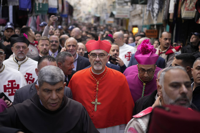Patriark Latin Pierbattista Pizzaballa, rohaniwan Katolik terkemuka selama prosesi tradisional Kristen menuju Gereja Kelahiran yang secara tradisional diyakini sebagai tempat kelahiran Yesus, pada Malam Natal di Bethlehem, Selasa (24/12/2024). Foto: Matias Delacroix/AP Photo
