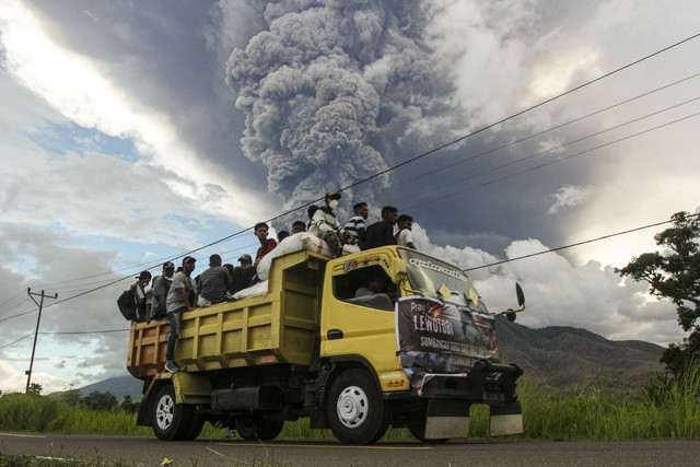 Truk yang membawa para relawan melintas saat terjadi erupsi Gunung Lewotobi Laki-laki di Desa Konga, Kecamatan Titehena, Kabupaten Flores Timur, Provinsi Nusa Tenggara Timur, Kamis (7/11/2024). Foto: Mega Tokan/ANTARA FOTO