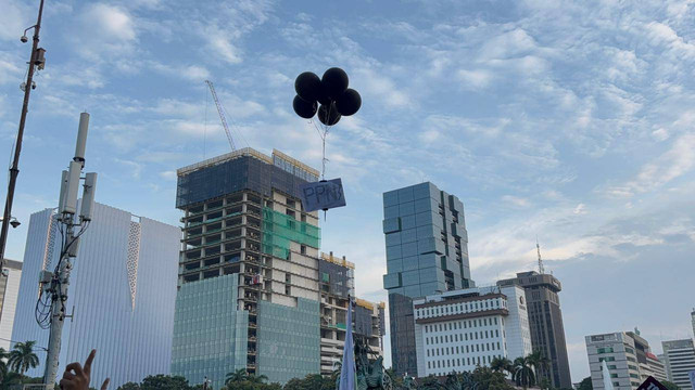 Masa aksi tolak PPN 12 persen di Patung Kuda, Jakarta menerbangkan balon bertuliskan "PPN" pada Jumat (27/12). Foto: Abid Raihan/kumparan