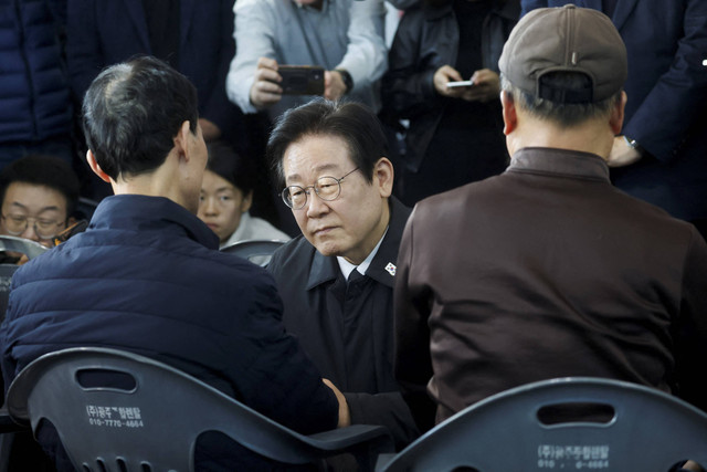 Pemimpin oposisi Partai Demokrat Korea Selatan, Lee Jae-myung, bertemu dengan anggota keluarga korban kecelakaan pesawat Jeju Air di Bandara Internasional Muan, di Muan, Korea Selatan, Senin (30/12/2024). Foto: Kim Soo-Hyeon/REUTERS