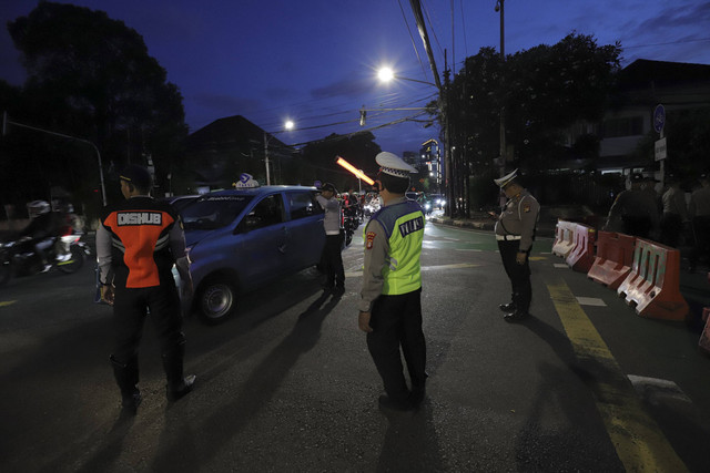 Polisi mengarahkan pengemudi saat Hari Bebas Kendaraan untuk perayaan pergantian malam tahun baru di Jalan Sudirman, Jakarta, Selasa (31/12/2024). Foto: Jamal Ramadhan/kumparan