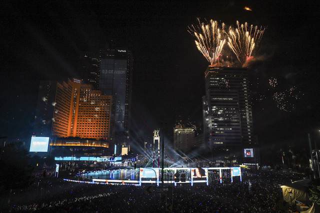 Sejumlah warga menyaksikan pesta kembang api saat malam perayaan tahun baru 2025 di kawasan Bundaran HI, Jakarta, Rabu (1/1/2025). Foto: Iqbal Firdaus/kumparan