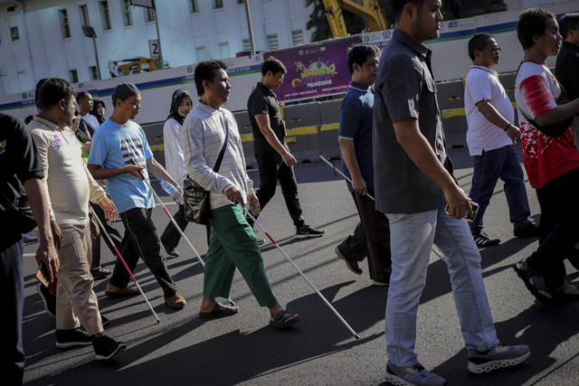 Para penyandang tunanetra berjalan di kawasan Car Free Day (CFD) saat peringati Hari Braille Sedunia di Jalan MH Thamrin, Jakarta, Minggu (5/1/2025). Foto: Jamal Ramadhan/kumparan