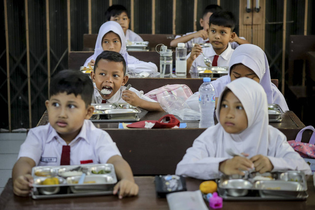 Siswa SDN Slipi 15 menyantap makanan dari program makan gratis nasional di ruang kelas SDN Slipi 15, Jakarta Barat, Senin (6/1/2025). Foto: Jamal Ramadhan/kumparan