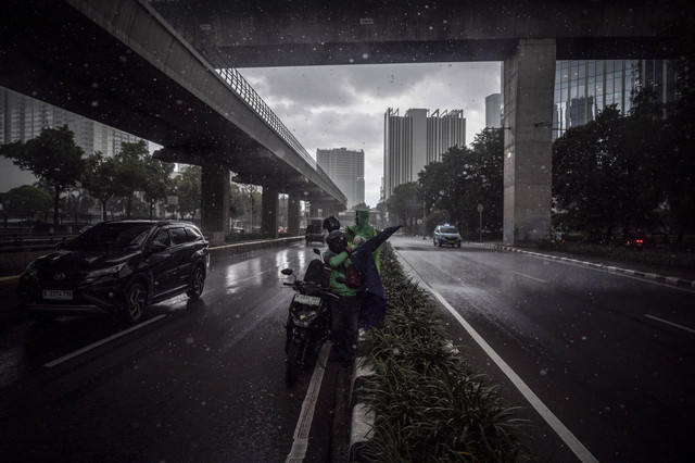 Pengendara sepeda motor memakai mantel saat hujan di kawasan Kuningan, Jakarta, Selasa (7/1/2024). Foto: Aprillio Akbar/ANTARA FOTO