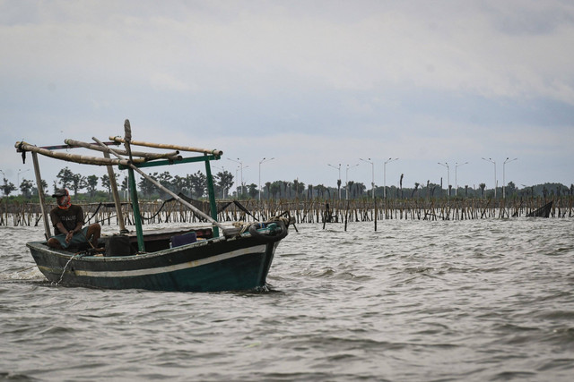 Perahu nelayan melintas di dekat pagar laut misterius di kawasan pesisir Kabupaten Tangerang, Banten, Kamis (9/1/2025). Foto: Sulthony Hasanuddin/ANTARA FOTO
