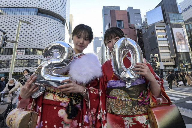 Para wanita muda yang mengenakan kimono berpose untuk foto untuk menandai "Hari Kedewasaan" di daerah Ginza, pusat kota Tokyo, Senin (13/1/2025). Foto: Richard A. Brooks / AFP
