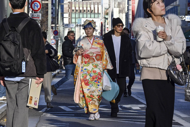 Para wanita muda yang mengenakan kimono berpose untuk foto untuk menandai "Hari Kedewasaan" di daerah Ginza, pusat kota Tokyo, Senin (13/1/2025). Foto: Richard A. Brooks / AFP
