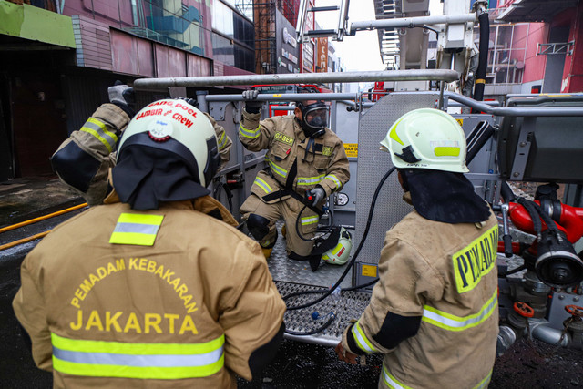 Petugas pemadam kebakaran menggunakan kendaraan High Pressure Pump Unit untuk melakukan pendinginan Glodok Plaza akibat kebakaran, Kamis (16/1/2025). Foto: Iqbal Firdaus/kumparan