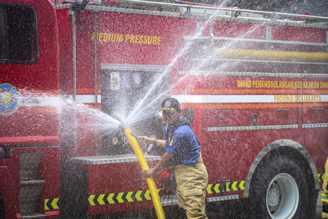 Petugas Damkar menyalakan selang air usai memadamkan kebakaran di Glodok Plaza, Jakarta, Jumat (17/1/2025). Foto: Iqbal Firdaus/kumparan
