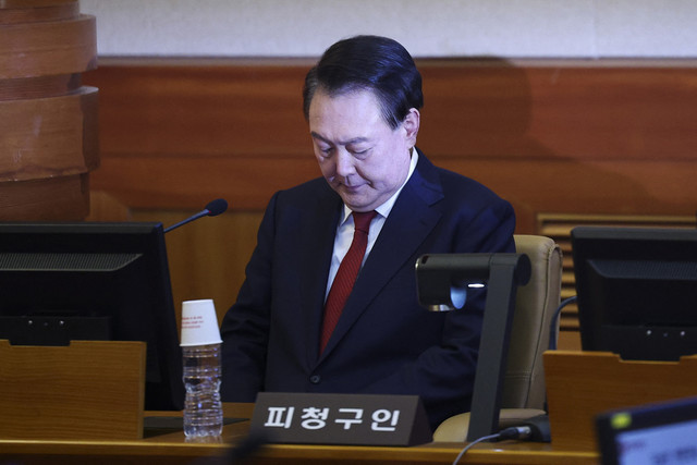 Presiden Korea Selatan yang dimakzulkan, Yoon Suk Yeol mengikuti sidang perdana pemakzulan di Mahkamah Konstitusi, Seoul, Korea Selatan, Selasa (21/1/2025). Foto: KIM HONG-JI/AFP