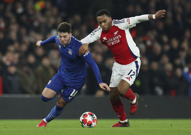 Martin Baturina dari GNK Dinamo Zagreb beraksi dengan Jurrien Timber dari Arsenal pada pertandingan Liga Champions antara Arsenal vs GNK Dinamo Zagreb di Stadion Emirates, London, Inggris, Kamis (23/1/2025) dini hari. Foto: Paul Childs/REUTERS