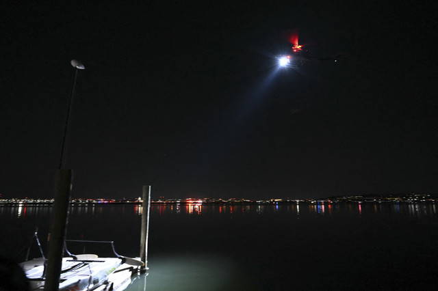 helikopter pencarian dan penyelamatan mencari di perairan Sungai Potomac setelah sebuah pesawat yang sedang mendekat ke Bandara Nasional Reagan jatuh ke sungai, terlihat dari Alexandria, Virginia, 30 Januari 2025. Foto: Andrew Caballero-Reynolds/AFP
