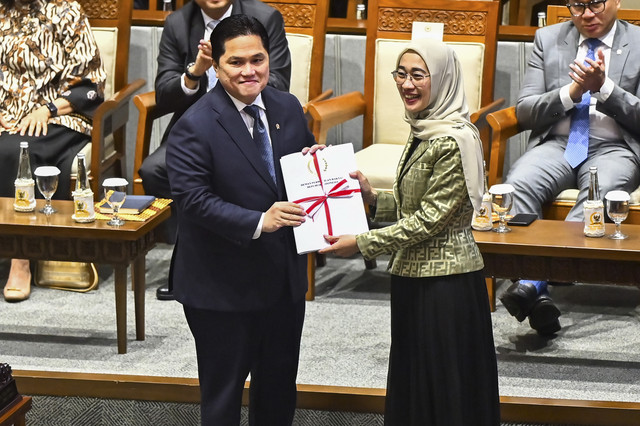 Menteri BUMN Erick Thohir (kiri) menerima laporan dari Ketua Komisi VI DPR RI Anggia Ermarini (kanan) saat Rapat Paripurna ke-12 Masa Persidangan II Tahun Sidang 2024-2025 di Kompleks Parlemen, Senayan, Jakarta, Selasa (4/2/2025).  Foto: Rivan Awal Lingga/ANTARA FOTO