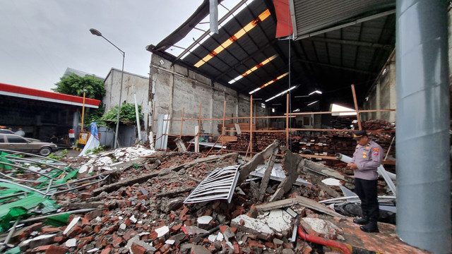 Tembok pembatas toko bangunan dengan SPBU di Kecamatan Sukomanunggal, Surabaya, roboh, Kamis (13/2/2025). Foto: Farusma Okta Verdian/kumparan
