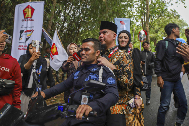 Anggota DPR RI Ahmad Dhani dan istri sekaligus Anggota DPR RI Mulan Mulan Jameela menaiki sepeda motor yang dikendarai oleh petugas keamanan usai mengikuti pertemuan dengan Presiden Prabowo di Padepokan Garuda Yaksa, Hambalang, Bogor, Jumat (14/2). Foto: Iqbal Firdaus/kumparan