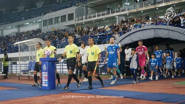 Ofisial wasit diikuti para pemain PSM Makassar dan Persib Bandung masuk lapangan jelang sebuah laga Liga 1 musim 2024/25. Foto: ligaindonesiabaru.com