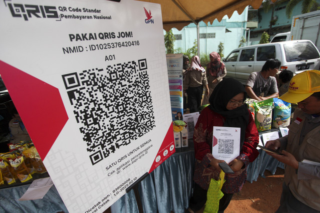 Pengunjung memindai kode pembayaran digital saat sosialisasi penggunaan QRIS Kantor Perwakilan Bank Indonesia Kepulauan Riau (KPw BI Kepri) pada gelaran pasar murah di Batam, Kepulauan Riau, Jumat (21/2/2025). Foto: ANTARA FOTO/Teguh Prihatna
