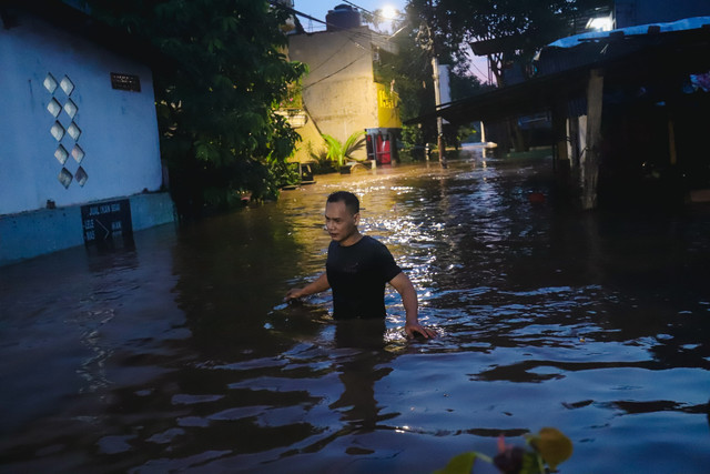 Warga berjalan melewati banjir yang merendam permukiman warga di Pejaten Timur, Pasar Minggu, Jakarta Selatan, Senin (3/3/2025). Foto: Jamal Ramadhan/kumparan