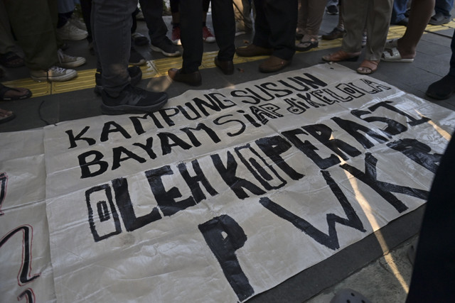 Poster yang dibawa warga eks kampung bayam yang tergabung dalam Persaudaraan Warga Kebun Bayam (PWKB) berbincang di luar Jakarta International Stadium (JIS), Jakarta, Kamis (6/3/2025). Foto: Jamal Ramadhan/kumparan