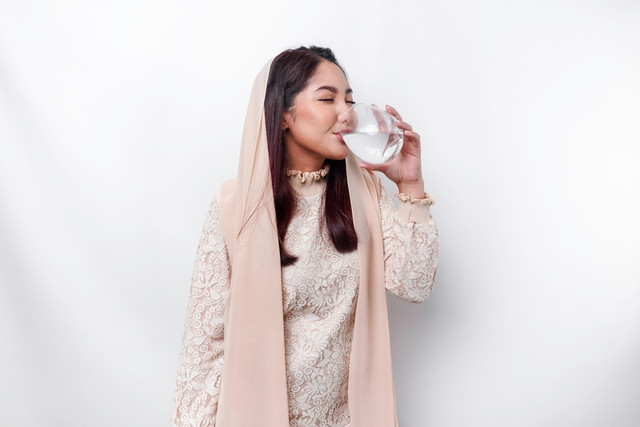 Ilustrasi perempuan minum air putih. Foto: Shutterstock